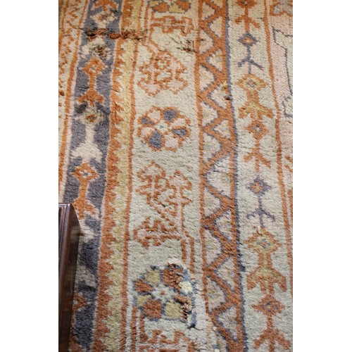 389 - A large Turkish wool carpet, in orange and cream colourways with a larger central medallion, 406cm x... 