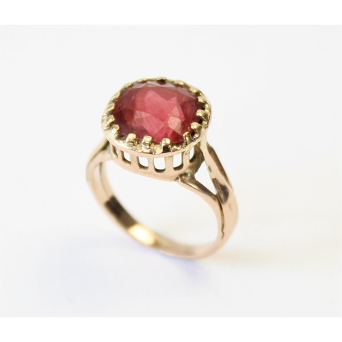 107 - A tourmaline ring, the central orange-pink cushion cut tourmaline (measuring 8.8mm x 8.9mm), claw se... 