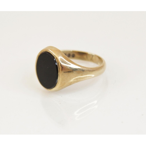 116 - A 9ct gold black onyx signet ring, the oval onyx panel measuring 12mm x 10mm, set in 9ct yellow gold... 