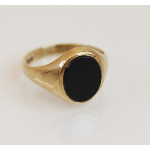 116 - A 9ct gold black onyx signet ring, the oval onyx panel measuring 12mm x 10mm, set in 9ct yellow gold... 