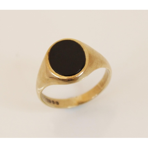 116 - A 9ct gold black onyx signet ring, the oval onyx panel measuring 12mm x 10mm, set in 9ct yellow gold... 