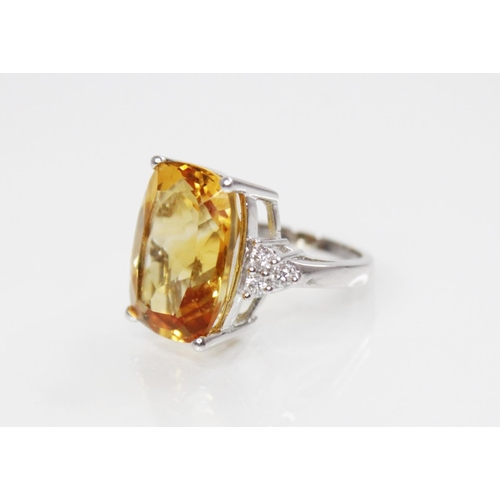 140 - A citrine and diamond 18ct gold ring, the central rectangular mixed cut citrine (measuring 18mm L x ... 