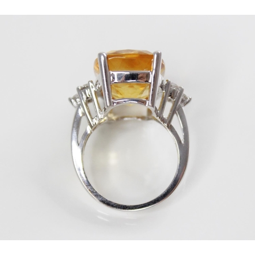 140 - A citrine and diamond 18ct gold ring, the central rectangular mixed cut citrine (measuring 18mm L x ... 