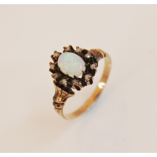 148 - An early 20th century opal and diamond cluster ring, comprising a central opal cabochon (measuring 6... 