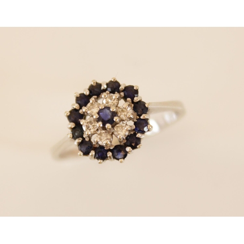 154 - An 18ct gold sapphire and diamond floral cluster ring, comprising six round brilliant cut diamonds a... 