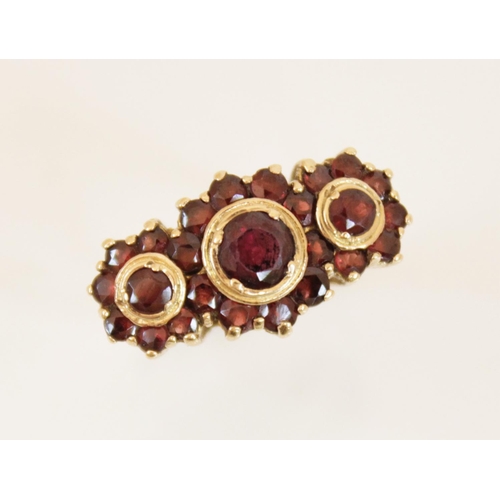 157 - A 9ct gold garnet cluster ring, comprising three principle round mixed cut garnets (measuring betwee... 