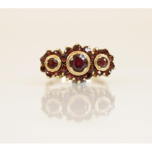 157 - A 9ct gold garnet cluster ring, comprising three principle round mixed cut garnets (measuring betwee... 