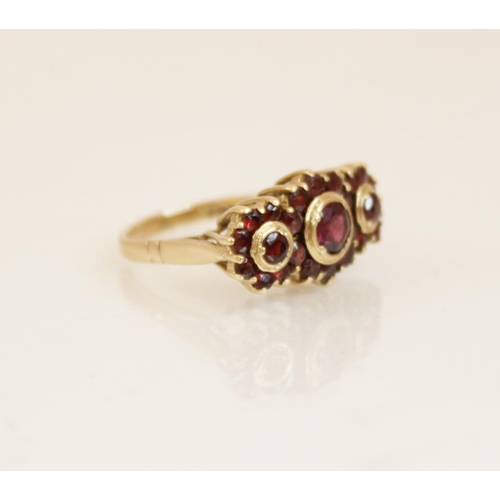 157 - A 9ct gold garnet cluster ring, comprising three principle round mixed cut garnets (measuring betwee... 