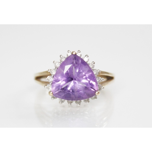 173 - An amethyst and diamond 9ct gold cluster ring, the central triangular mixed cut amethyst measuring 1... 