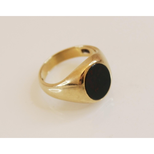 181 - A 9ct bloodstone signet ring, the central oval bloodstone panel (measuring 11mm x 9mm), rub-over set... 