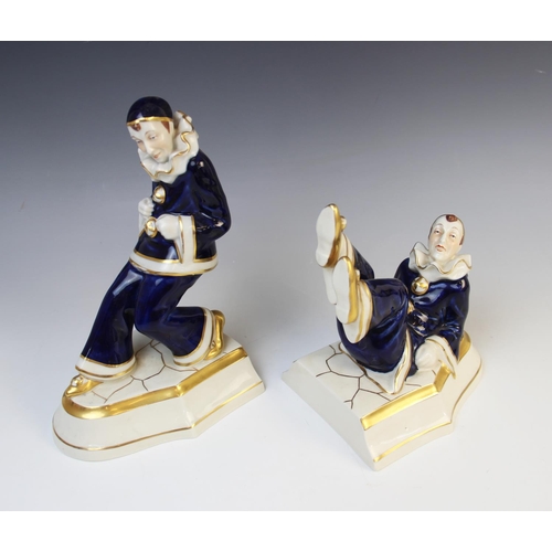 506 - A pair of Royal Dux Pierrot bookends, one modelled leaning, the other with his feet in the air, each... 