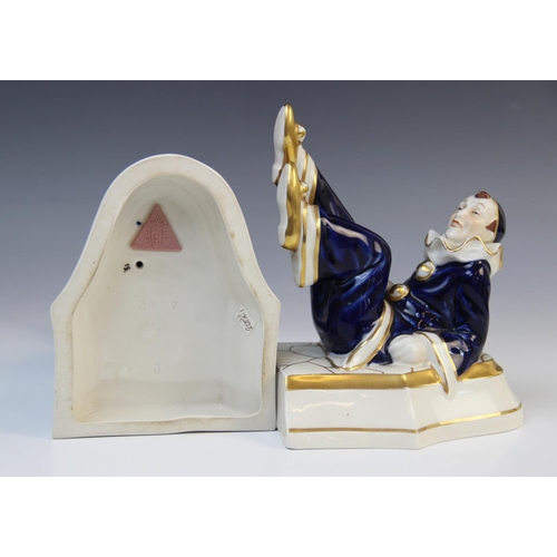 506 - A pair of Royal Dux Pierrot bookends, one modelled leaning, the other with his feet in the air, each... 