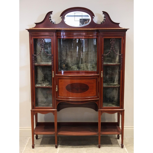 861 - An Edwardian inlaid mahogany display cabinet, the mirrored pediment over a central concave glazed pa... 