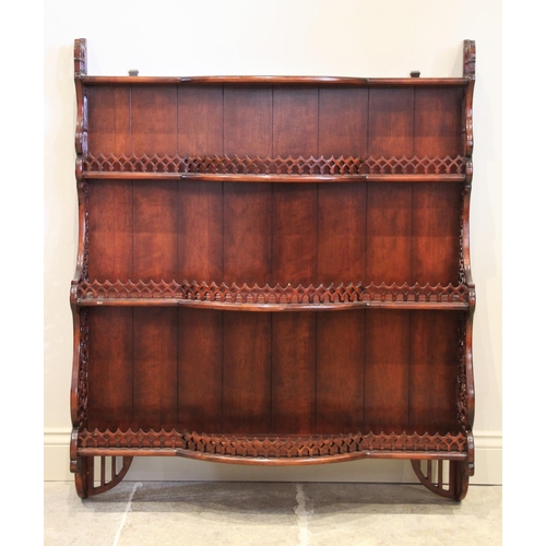 862 - A reproduction stained hardwood wall shelf, the three break arch open shelves with a pierced gallery... 