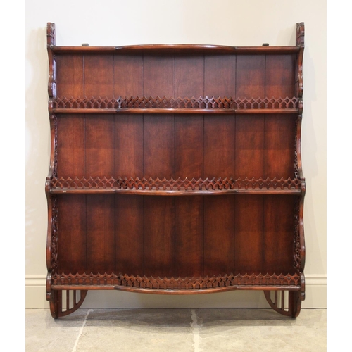 862 - A reproduction stained hardwood wall shelf, the three break arch open shelves with a pierced gallery... 