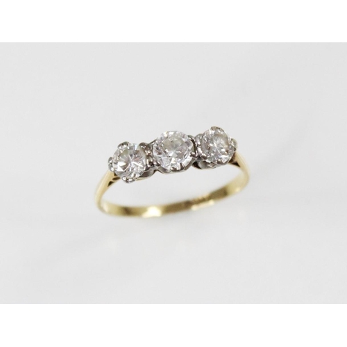 109 - A diamond three stone ring, comprising a central round brilliant cut diamond (weighing approximately... 