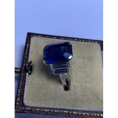 186 - An Art Deco sapphire and diamond ring, the central octagonal step cut sapphire (measuring 11.79mm L ... 