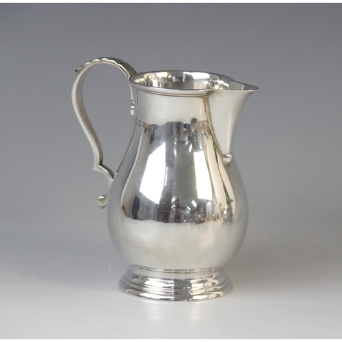 40 - A George VI silver milk jug by Blackmore & Fletcher Ltd, London 1938, of baluster form on stepped ci... 