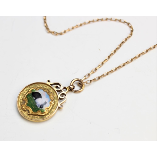 99 - A 9ct yellow gold and enamel Dutch rabbit pendant, the circular pendant fob with central panel depic... 