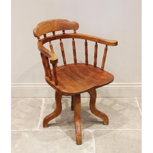 875 - An early 20th century stained beech wood revolving desk chair, the horse shoe shaped top rail raised... 