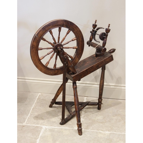 864 - An early 20th century oak spinning wheel, extensively carved and dated 1902, 88cm x 80cm