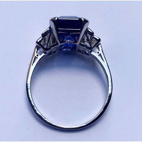 186 - An Art Deco sapphire and diamond ring, the central octagonal step cut sapphire (measuring 11.79mm L ... 