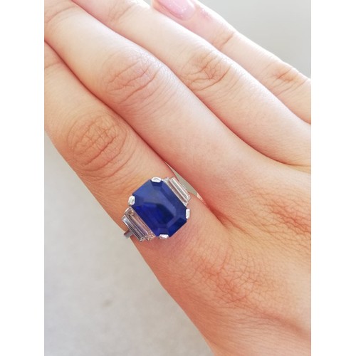 186 - An Art Deco sapphire and diamond ring, the central octagonal step cut sapphire (measuring 11.79mm L ... 