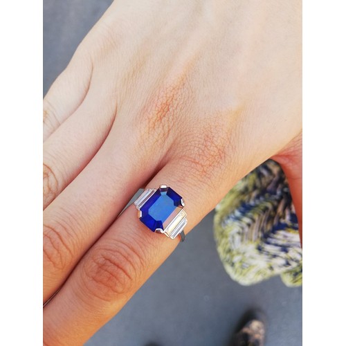 186 - An Art Deco sapphire and diamond ring, the central octagonal step cut sapphire (measuring 11.79mm L ... 