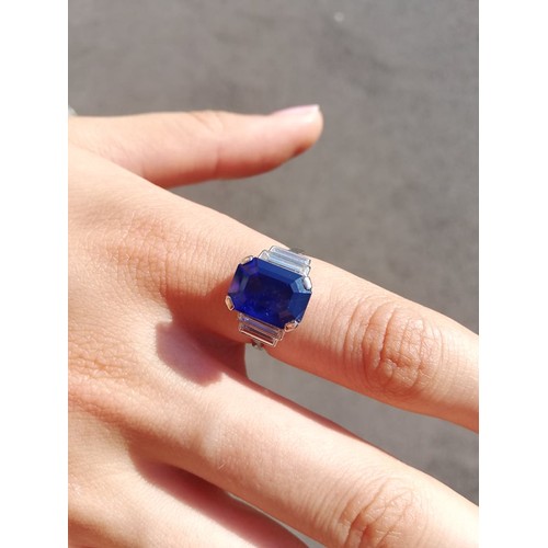 186 - An Art Deco sapphire and diamond ring, the central octagonal step cut sapphire (measuring 11.79mm L ... 