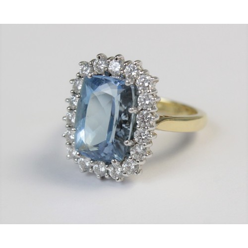 141 - An aquamarine and diamond 18ct gold cluster ring, the central rectangular mixed cut aquamarine (meas... 