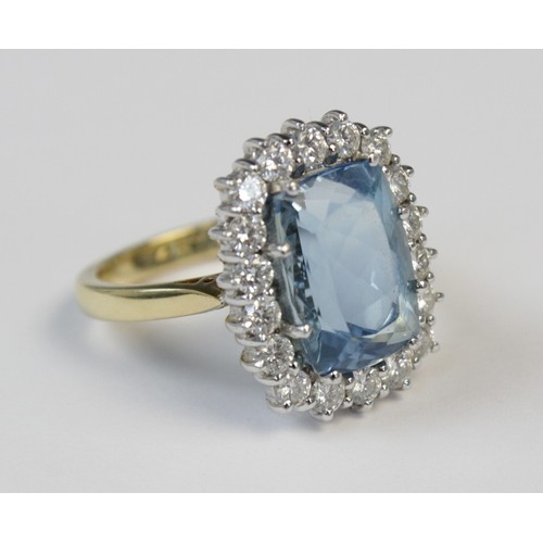 141 - An aquamarine and diamond 18ct gold cluster ring, the central rectangular mixed cut aquamarine (meas... 