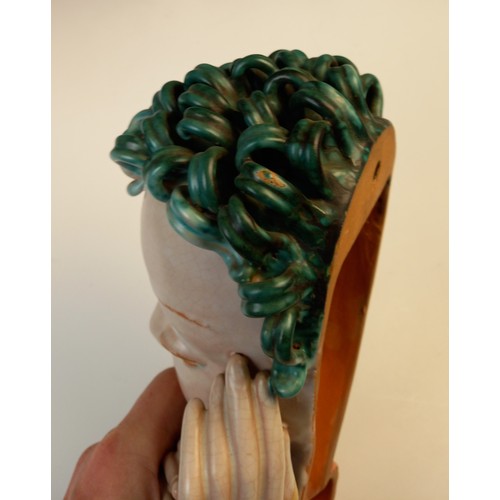 503 - An Art Deco Goldscheider wall mask, early 20th century, modelled as a lady with blue curled hair and... 