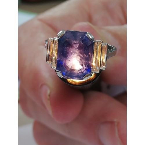 186 - An Art Deco sapphire and diamond ring, the central octagonal step cut sapphire (measuring 11.79mm L ... 