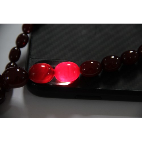 128 - A cherry amber bead necklace, comprising fifty-seven polished oval beads measuring between 8mm x 6mm... 