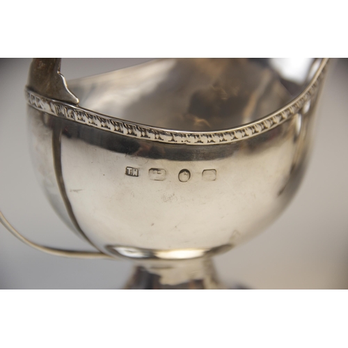 101 - A Victorian silver sauce boat by Thomas Hayes, Birmingham 1892, of helmet form on pedestal foot with... 