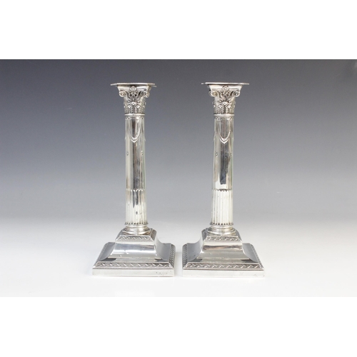 136 - A pair of late Victorian silver candlesticks by Goldsmiths & Silversmiths Co, London 1899, the Corin... 