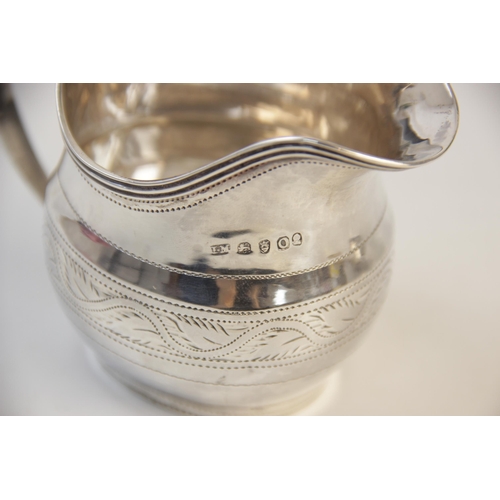 140 - A George III silver cream jug by John Merry, London 1809, of helmet form with engraved foliate borde... 