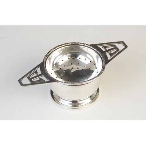 55 - A George IV silver tea strainer and stand by G W Lewis & Co, Birmingham 1941, the circular bowl with... 
