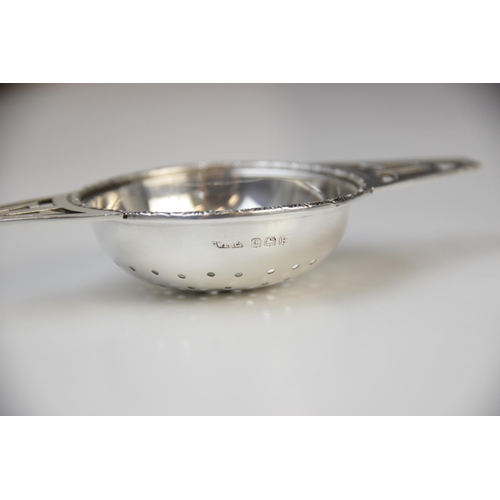 55 - A George IV silver tea strainer and stand by G W Lewis & Co, Birmingham 1941, the circular bowl with... 