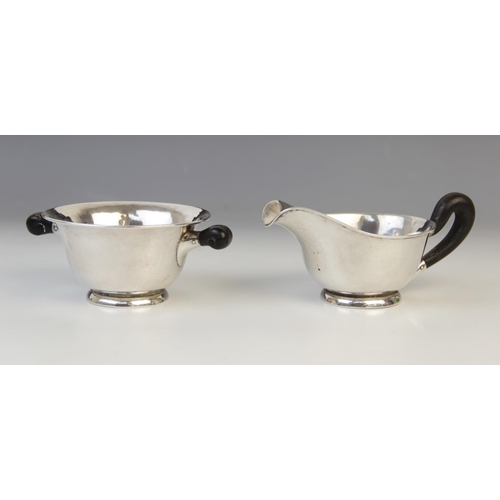 72 - A continental silver milk jug and sucrier, each with flared rims on raised circular feet with ebonis... 