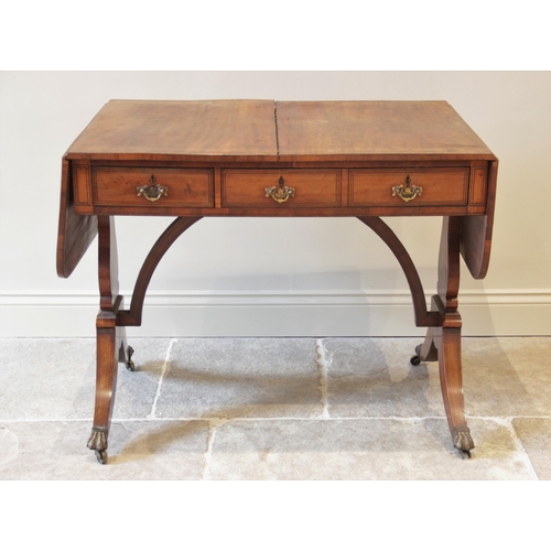 827 - A Regency maple sofa table, in the manner of George Bullock, the rectangular top with rounded drop l... 