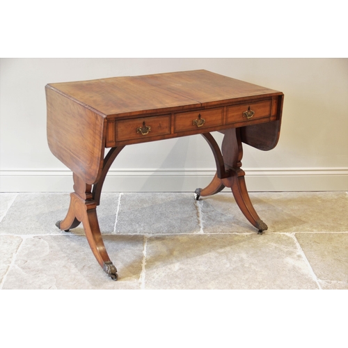 827 - A Regency maple sofa table, in the manner of George Bullock, the rectangular top with rounded drop l... 