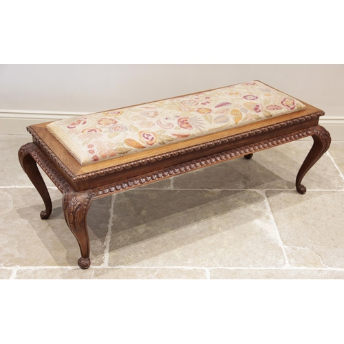 929 - A mid 20th century carved hardwood and upholstered long stool, the rectangular drop in crewel work s... 