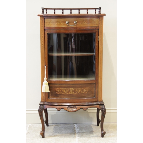 933 - An Edwardian mahogany bowfront display cabinet, the shaped top with a rear spindle gallery, above a ... 