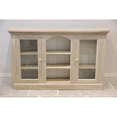 948 - A painted hardwood display cabinet, the rectangular top above a central arched recess with two open ... 