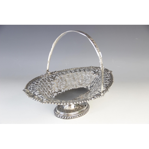 98 - An Edwardian silver swing-handled basket, London 1907 (maker’s marks worn), of oval form on pedestal... 