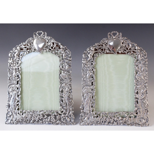 75 - A pair of Victorian silver photograph frames by William Comyns, London 1894, of arched rectangular f... 