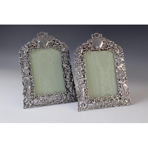 75 - A pair of Victorian silver photograph frames by William Comyns, London 1894, of arched rectangular f... 