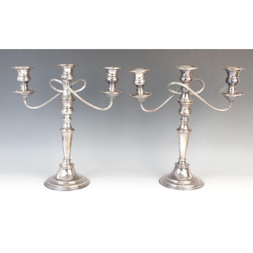 147 - A pair of silver plated candelabras by Elkington & Co, each with tapering knopped columns on stepped... 