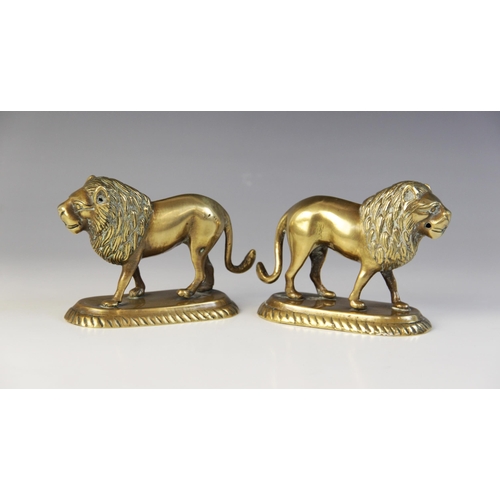 104 - A pair of Indian brass models of lions, late 19th/early 20th century, each modelled standing on an o... 